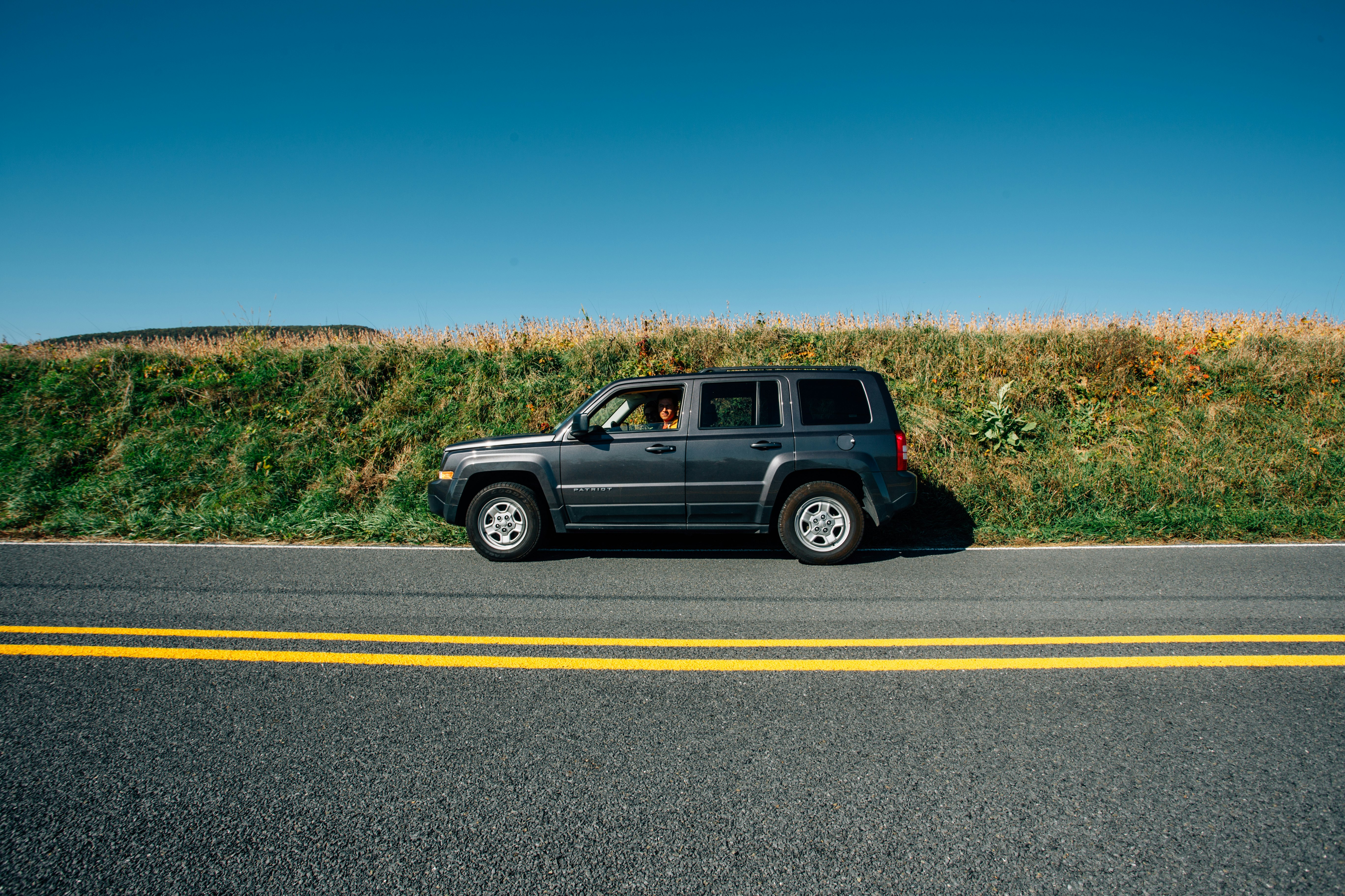 black suv on gray asphalt road during daytime